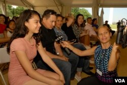 Padres de un menor hispano que se naturalizó estadounidense en el Festival Folclórico del Smithsonian, conversan con Verónica Balderas de la VOA. Foto: Alejandro Escalona. Junio 30, 2017.