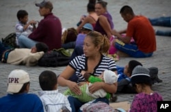 Una migrante hondureña amamanta a su hija antes de comenzar a caminar nuevamente como parte de una caravana de cientos de migrantes hondureños que se dirigen a Estados Unidos. Esquipulas, Guatemala. Martes 16 de octubre de 2018.