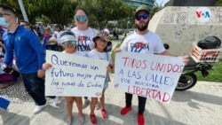 Una familia posa con carteles en el que se exige la libertad de Cuba y un futuro mejor para las nuevas generaciones de cubanos.