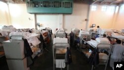 Archivo: - En esta foto del 14 de junio de 2009, se observan camarotes de tres pisos en un gimansio acondicionado para retener a privados de libertad en el California Substance Abuse Treatment Facility and State Prison de Corcoran, Calif.