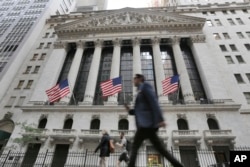 People walk by the New York Stock Exchange on June 24, 2016, the morning after Britain voted to leave the European Union. Global markets tumbled. (AP)