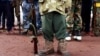 FILE - A former child soldier holds a gun as he and others participate in a child soldiers' release ceremony, outside Yambio, South Sudan, Aug 7, 2018.