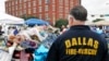 A Dallas firefighter pays respects at the makeshift memorial for fallen officers outside Dallas police headquarters in Texas, July 11, 2016. (M. O'Sullivan/VOA)