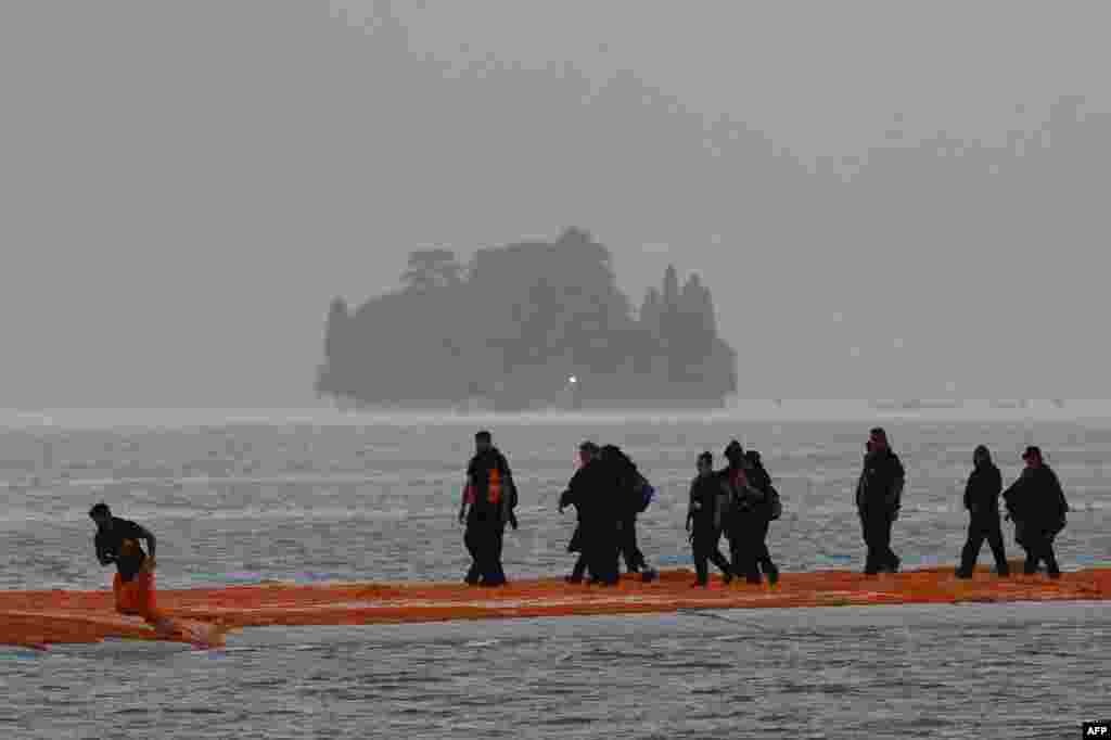 Para pekerja menyelesaikan konstruksi &quot;Dermaga Mengambang&quot; di Danau Iseo, Italia utara.