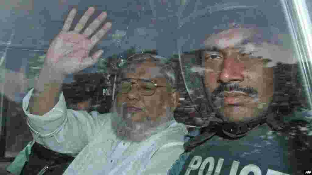 Secretary General of Jamaat-e-Islami Ali Ahsan Mohammad Mujahid waves from a police vehicle as he is transported to the central jail following his court verdict in Dhaka, Bangladesh, July 17, 2013.