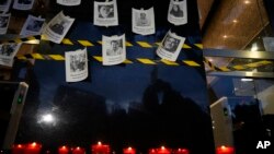 ARCHIVO - Fotos de periodistas asesinados se exhiben en una pared durante una vigilia para protestar por el asesinato del periodista Fredid Roman, frente a la oficina del Fiscal General de México en la Ciudad de México, el 24 de agosto de 2022.