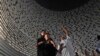 Visitors look at a wall displaying the names of the victims of 2004 Indian Ocean tsunami, at the Tsunami Museum in Banda Aceh, Aceh province, Indonesia, Dec 14, 2024. 