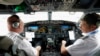 FILE - American Airlines pilot captain Pete Gamble, left, and first officer John Konstanzer conduct a pre-flight check before taking off from Dallas Fort Worth airport on Dec. 2, 2020, in Grapevine, Texas.