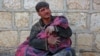 FILE - A Syrian man weeps as he cradles the body of his daughter who was killed following reported shelling in the town of Khan Sheikhun in the southern countryside of the rebel-held Idlib province, Feb. 26, 2019. 