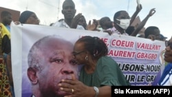 Un partisan de l'ancien président ivoirien Laurent Gbagbo, fondateur du Front populaire ivoirien (FPI), embrasse son portrait sur une banderole à Abidjan, le 31 août 2020.