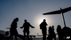 En esta imagen proporcionada por la Fuerza Aérea, aviadores estadounidenses guían a los evacuados a bordo de un C-17 Globemaster III en el Aeropuerto Internacional Hamid Karzai, en Kabul, Afganistán, el 24 de agosto de 2021.