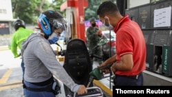 Marlene de Abreu llena el tanque de su moto en una gasolinera en Caracas. 7 de junio de 2020.
