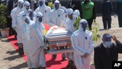 Health officials carry the coffin of Zimbabwean minister Perence Shiri, who died of COVID-19, during his burial in Harare.