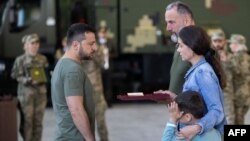 El presidente ucraniano, Volodymyr Zelenskyy, entrega una condecoración a la viuda de un teniente coronel nombrado postumamente Héroe de Ucrania, durante una reunión con funcionarios de inteligencia el 7 de septiembre de 2023.