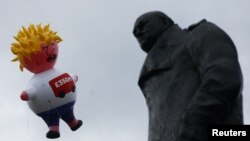 FILE - A giant inflatable blimp representing Boris Johnson is flown near a statue of former British Prime Minister Winston Churchill near the Houses of Parliament, ahead of an anti-Brexit 'No to Boris, Yes to Europe' protest in London, July 20, 2019.