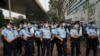 Agentes de policía apoyan a activistas a favor de la democracia que enfrentan cargos relacionados con la seguridad nacional y se reúnen frente a los tribunales de magistrados de West Kowloon, en Hong Kong, China, el 1 de marzo de 2021.