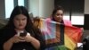 LGBTQ+ activist Waaddao Chumaporn holds a pride flag while in a waiting room with activist and representative of the marriage-equality bill Chanya Rattanatada at Thai Parliament in Bangkok on April 2, 2024, ahead of the first reading of the bill to the Senate.