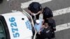 FILE - In this Tuesday, July 11, 2017 photo, New York City police officers detain and question a man in the Bronx borough of New York.