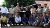 The seven Rohingya men to be deported sit as Indian and Myanmar security officials exchange documents before their deportation on India-Myanmar border at Moreh in the northeastern state of Manipur, India, Oct. 4, 2018.
