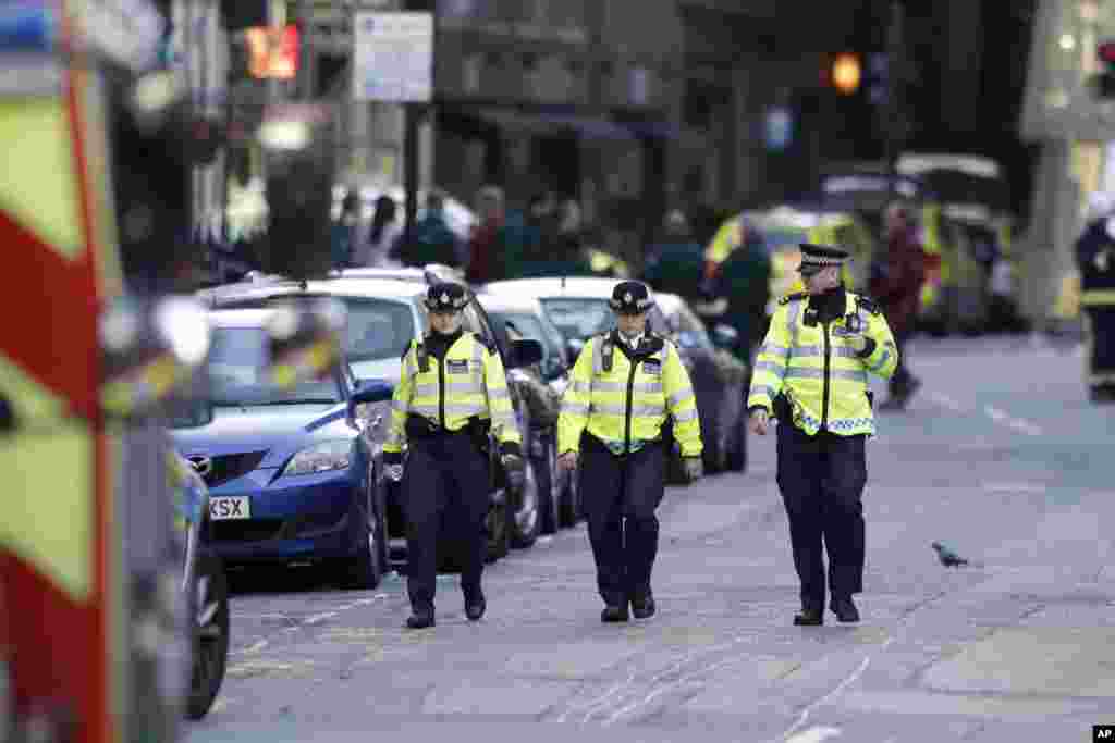 Policías británicos recorren la zona acordonada del Puente de Londres luego de un ataque el sábado por la noche que dejó 7 muertos y 48 heridos. Junio 4, 2017.&nbsp;