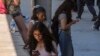 FILE - Students use their cellphones as they leave for the day the Ramon C. Cortines School of Visual and Performing Arts High School in Los Angeles, California, Aug. 13, 2024. 