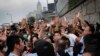 Student protesters resist during change of shift for local police but backed down after being reassured they could reoccupy the pavement outside the government compound’s gate in Hong Kong, Oct. 2, 2014.