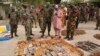 Military officials stand near ammunitions seized from suspected members of Hezbollah after a raid of a building in Kano, Nigeria, May 30, 2013.