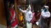 A health worker checks the body temperature of a resident, as others await their turn during a free medical checkup in a slum in Mumbai, India, Sunday, June 28, 2020. India is the fourth hardest-hit country by the COVID-19 pandemic in the world…
