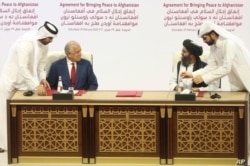 En esta foto de archivo del 29 de febrero de 2020, el enviado de paz de Estados Unidos, Zalmay Khalilzad, a la izquierda, y el mulá Abdul Ghani Baradar, el principal líder político del grupo talibán, firman un acuerdo de paz.