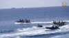 Personel angkatan laut Filipina mengumpulkan sisa-sisa paket makanan yang terapung di lautan Second Thomas Shoal, pada Minggu, 19 Mei 2024. (Foto: via AP)