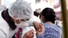 Un trabajador de salud aplica a una mujer la primera dosis de la vacuna Sinopharm fuera de la iglesia Monte de Oración en La Paz, el martes 28 de diciembre de 2021.