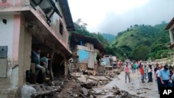 En esta foto de la oficina de prensa del gobierno del estado de Mérida, personas caminan por una calle dañada por inundaciones y deslizamientos de tierra en la zona del Valle del Mocotíes, Venezuela. [Foto: vía AP]