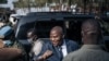 Le président de la République centrafricaine Faustin Archange Touadera (2e R) arrive au bureau de vote du lycée Barthélemy Boganda dans le 1er arrondissement de Bangui, en République centrafricaine (RCA), le 27 décembre 2020.