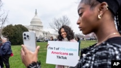 ARCHIVO - Las devotas de TikTok, Mona Swain, en el centro, y su hermana, Rachel Swain, a la derecha, ambas de Atlanta, posan con un cartel en el Capitolio en Washington, el 13 de marzo de 2024.