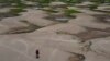 ARCHIVO - Un residente de una comunidad ribereña lleva alimentos y contenedores con agua potable luego de que fueron distribuidos debido a una sequía en Careiro da Varzea, en el estado de Amazonas, Brasil.