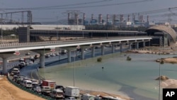 Vehículos circulan a través del agua estancada causada por fuertes lluvias en una rampa de acceso a la autopista Sheikh Zayed Road en Dubai, Emiratos Árabes Unidos, el jueves 18 de abril de 2024.