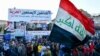 Iraquíes en Nasiriya enarbolan una bandera nacional durante una protesta para rechazar la nominación de Mohamed Alaui como primer ministro. Febrero 2 de 2020. Foto: AFP