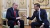 President Donald Trump and French President Emmanuel Macron gesture during their meeting inside the Elysee Palace in Paris, Nov. 10, 2018.