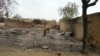 In this image shot with a mobile phone, a young girl stands amid the burned ruins of Baga, Nigeria, April 21, 2013.