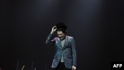 El artista español Joaquín Sabina saluda durante un concierto en Montevideo, el 23 de noviembre de 2019 en la capital uruguaya. Foto: AFP.