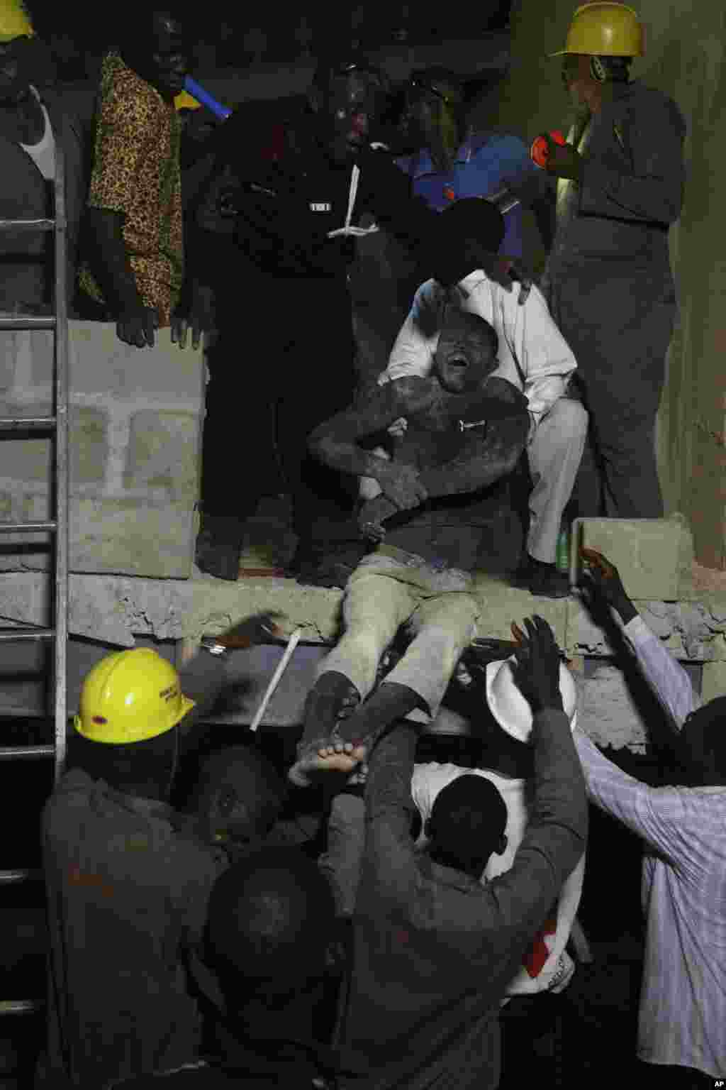 Rescue workers carry a survivor from the rubble of a building under construction which collapsed in Lagos, Nigeria, Nov, 4. 2013.