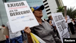 Una mujer sostiene pancartas durante un mitin para conmemorar el Día Mundial de la Libertad de Prensa en Caracas, Venezuela, Mayo 3, 2016.