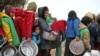 FILE - Syrian children queue to receive food distributed by humanitarian aid workers at a makeshift camp for displaced people, near the village of Yazi Bagh, Feb. 7, 2018. 