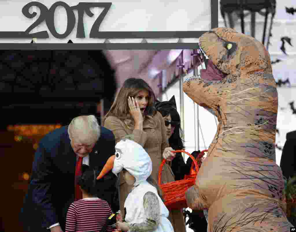ប្រធានាធិបតី​ Donald Trump និង​ស្រ្តី​ទី១ Melania Trump ឲ្យ​ស្ករគ្រាប់​ទៅ​កុមារខណ​ដែល​​​​ពួកគេ​ស្វាគមន៍​កុមារៗ​ពី​តំបន់​វ៉ាស៊ីនតោន​និង​កុមារ​ពី​គ្រួសារ​យោធា​ក្នុង​ពិធីបុណ្យ​ Halloween កាលពី​ថ្ងៃទី​៣០ តុលា ២០១៧។