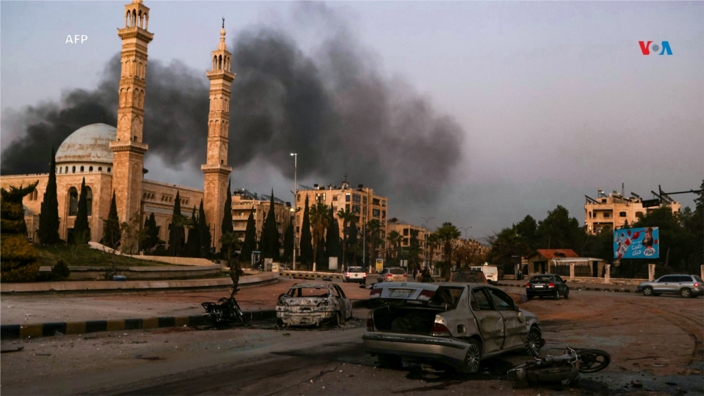 El humo se eleva a lo lejos mientras se ven automóviles dañados en el lugar de los ataques aéreos por parte del régimen sirio en la provincia de Idlib, al noroeste de Siria.