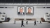 FILE - People walk past portraits of the late North Korean leaders Kim Il Sung and Kim Jong Il at Kim Il Sung Square in Pyongyang, North Korea.
