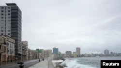 Un hombre camina en el malecón frente al mar durante el paso de la tormenta Eta, en La Habana, Cuba, el 8 de noviembre de 2020.