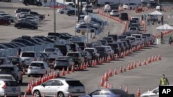 Múltiples automóviles hacen fila para ingresar a un centro de vacunación contra el COVID-19 en el Dodger Stadium, en Los Ángeles, el 25 de febrero de 2021.