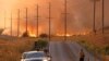 Un hombre se para en una carretera cerca de las llamas del incendio Rabbit en Moreno Valley en el condado de Riverside, California, el 14 de julio de 2023.