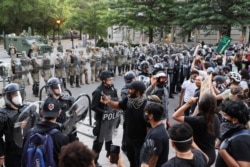 Agentes de policía hacen guardia mientras los manifestantes participan en una protesta cerca de la Casa Blanca contra la muerte en la custodia policial de George Floyd en Minneapolis, en Washington, DC, EE. UU., 1 de junio de 2020.